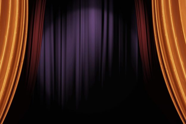 opening gold and red stage curtains in dark theater for a live p
