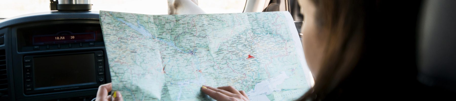 close-up-woman-checking-map-inside-car