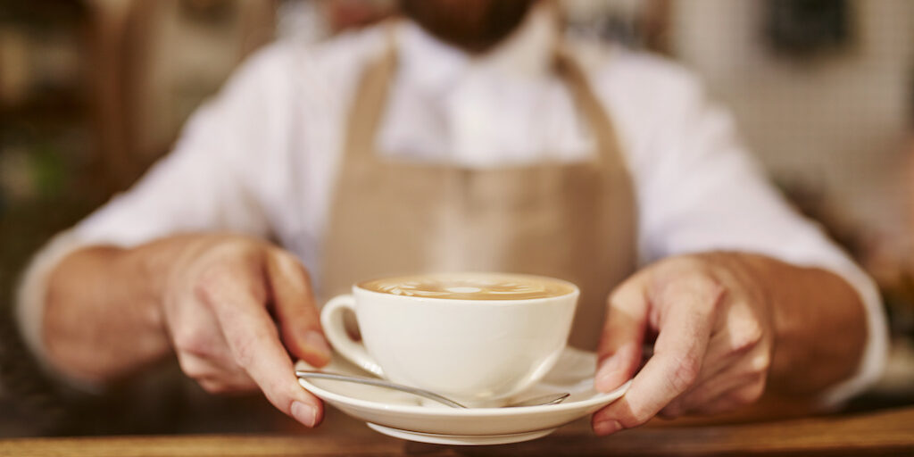Barista serving cup of fresh coffee for you
