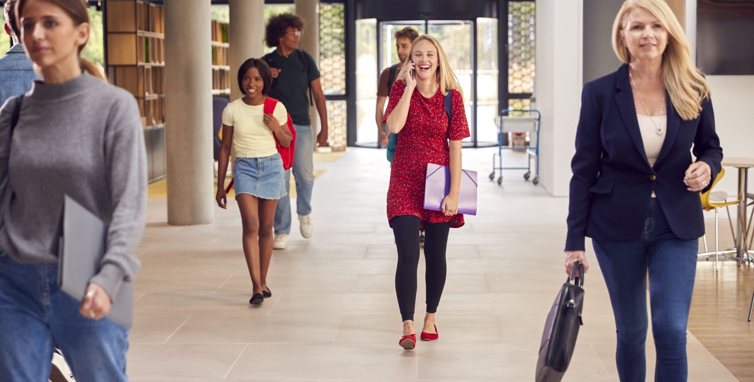 female-student-talks-on-mobile-phone-as-she-walks-2023-11-27-05-15-51-utc (1)