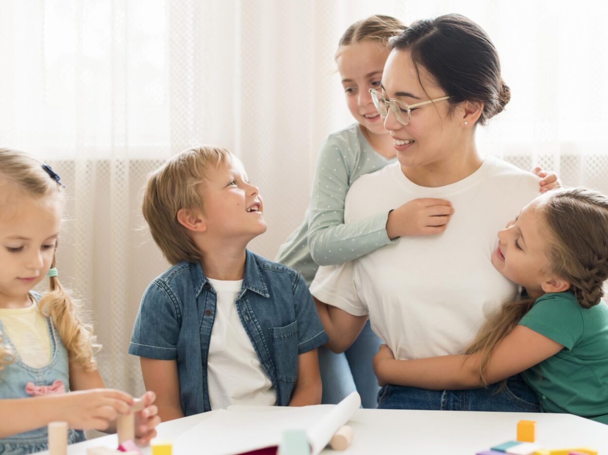 front-view-kids-hugging-their-teacher