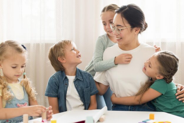 front-view-kids-hugging-their-teacher