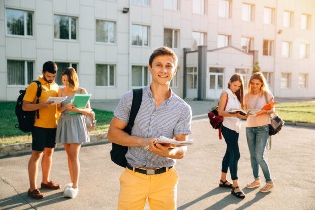Happy student with note-books and backpack smiling